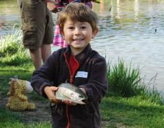 A young boy holding a fish he just caught at a National Fishing and Boating event. Photo credit: USFWS